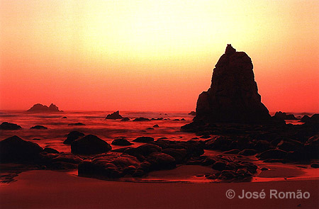 06176B Pormenor do lado norte da Praia da Aroeira. rochas silhueta areia mar vermelho castanho Parque-Natural-Sintra-Cascais